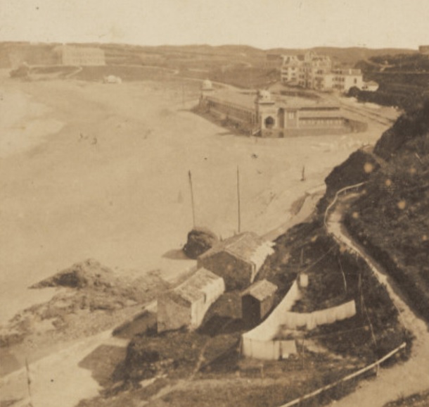 Biarritz : Bains Napoleon, pris du Casino. La construction des bains date de 1858 ; ils seront détruits en 1896. Vue panoramique sur la plage de l’Impératrice avec les Bains Napoléon et les premières maisons construites à proximité de la plage. A l’arrière-plan, la villa Eugénie et, au premier plan, des baraques de pécheurs et des filets qui sèchent.