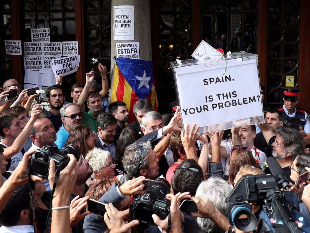 La foule porte en triomphe une urne portant une inscription en anglais : « Espagne, ceci est-il votre problème ? »