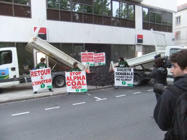 En 2014, Bizi déverse 1,8 tonnes de charbon devant le siège de la Société Générale dans une action spectaculaire intitulée “retour à l’envoyeur”.